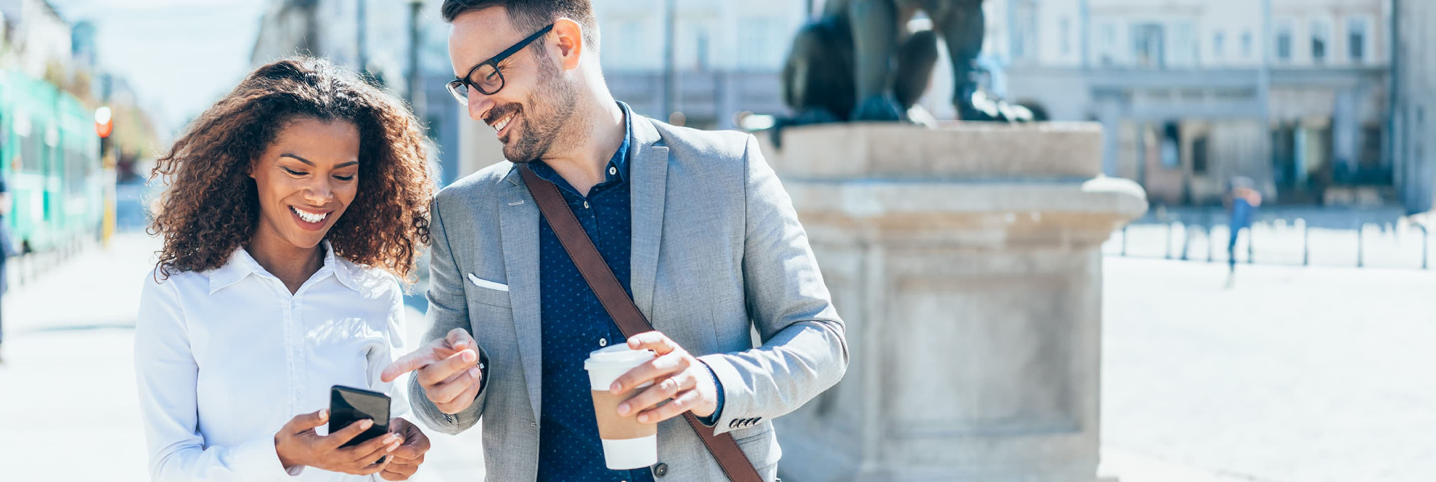 Man and woman smiling at cell phone