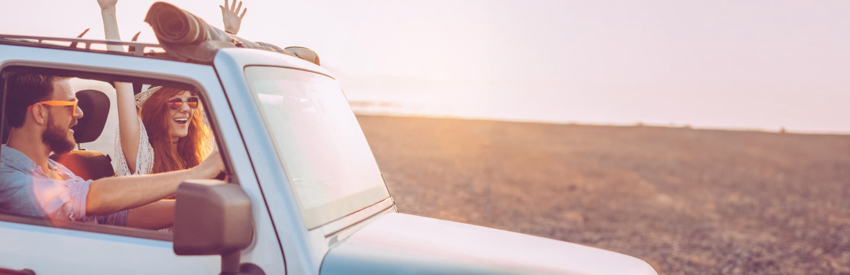 Man and woman driving on the beach