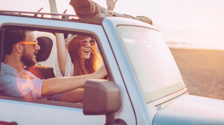 Man and woman driving on the beach